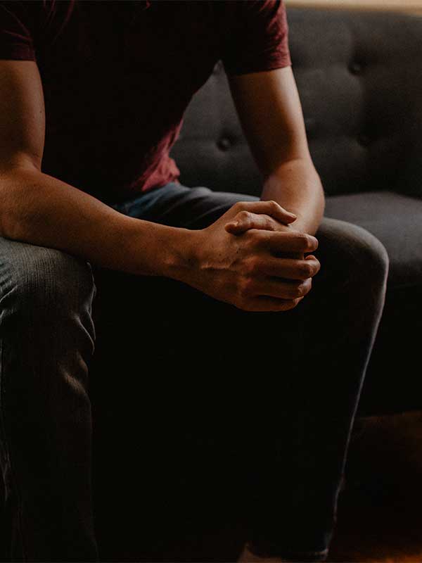 mental health clinicians seated man clasping hands